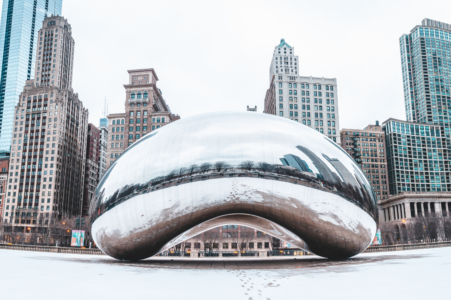 Chicago's Cloud Gate sculpture reflecting city skyline, showcasing urban innovation and architecture amid winter setting.