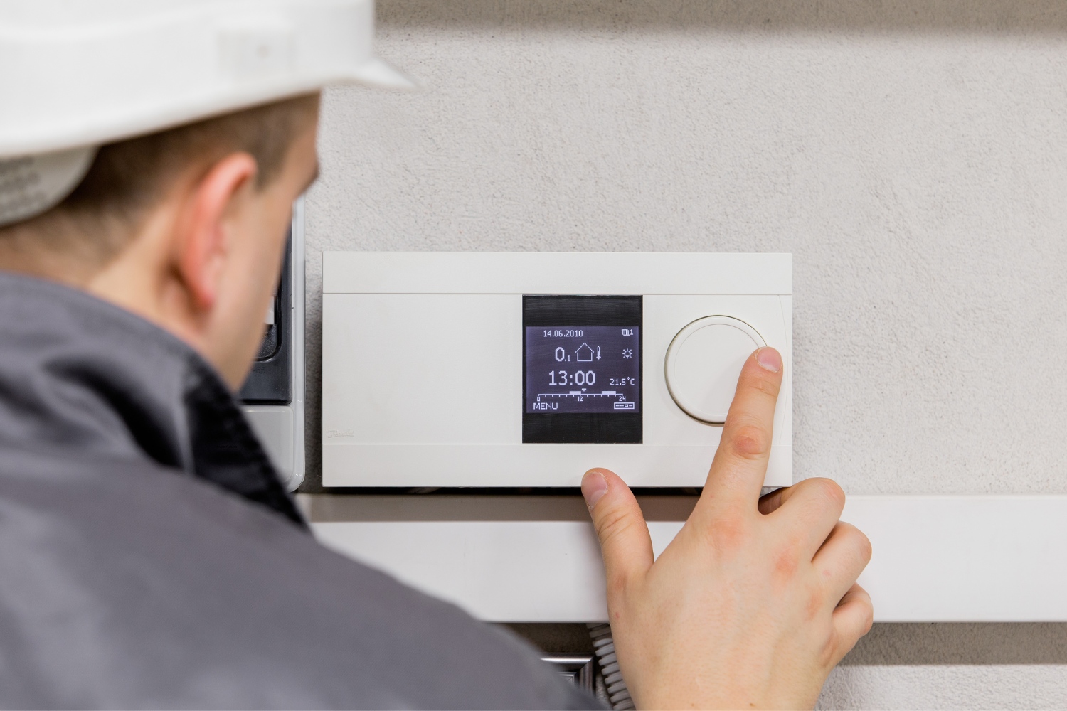HVAC Contractor adjusting a thermostat