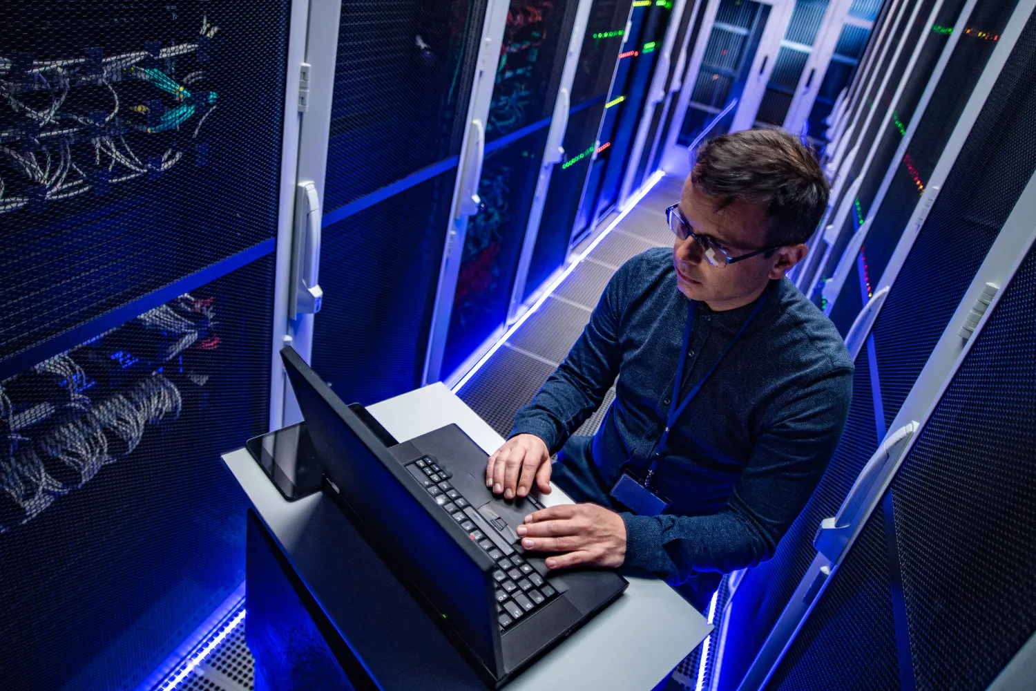 IT professional working on laptop in server room, emphasizing digital marketing and SEO strategies for 2024.