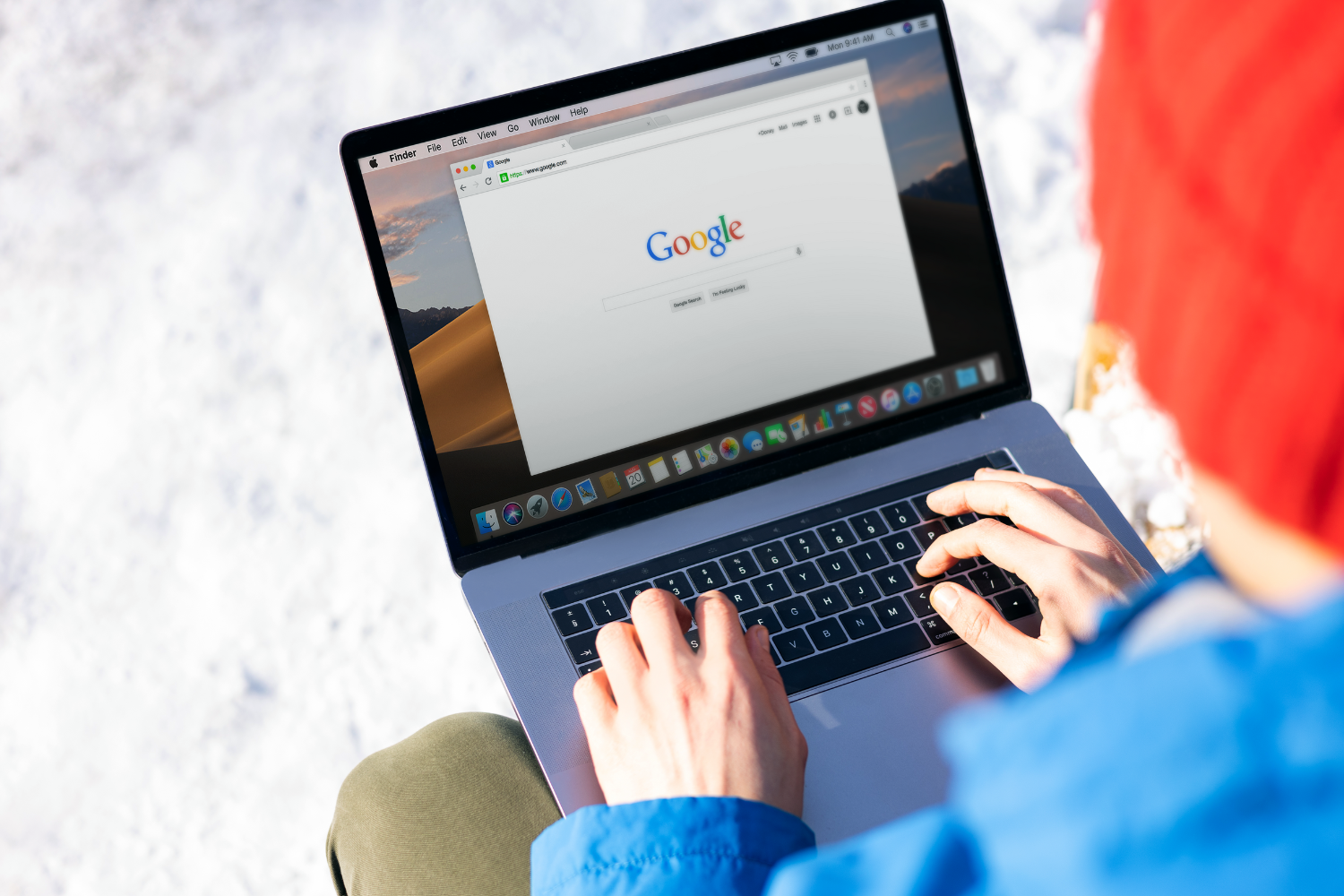 Person typing on a laptop outdoors with Google search page displayed, illustrating the importance of on-page SEO for enhancing website visibility and user engagement.