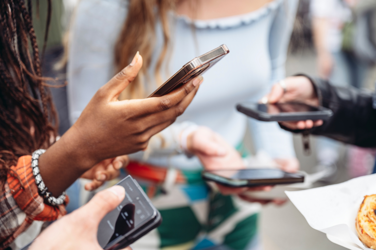 Group of individuals holding smartphones, engaged in social media interaction, reflecting digital marketing strategies and online engagement.