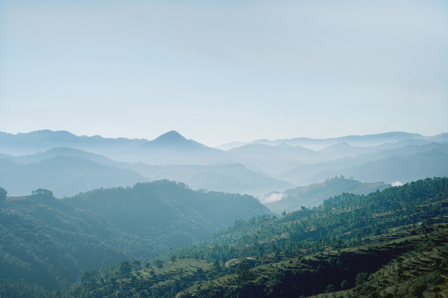Serene landscape of layered mountains and valleys under a clear blue sky, representing the tranquil backdrop for effective web design services that enhance online presence and user experience.