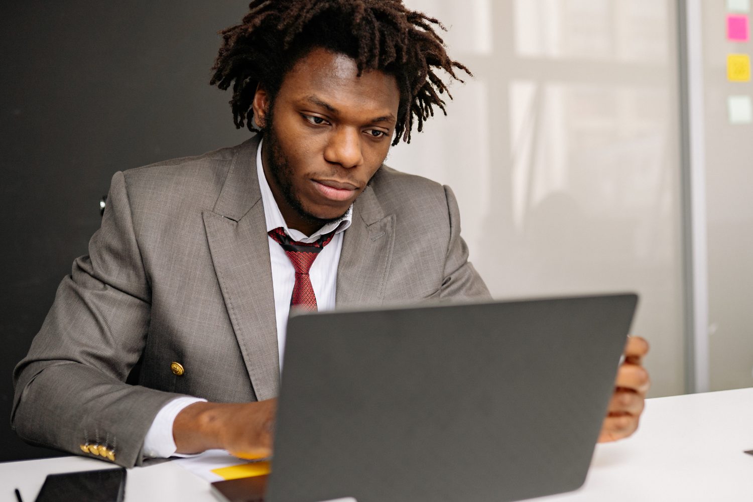 Business professional in a suit focused on laptop, illustrating digital marketing strategies for plumbing business growth.